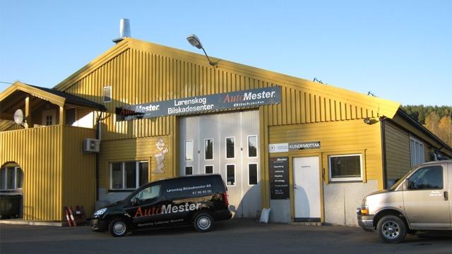 Gul verkstedbygning med skilt for AutoMester og en bil parkert foran.