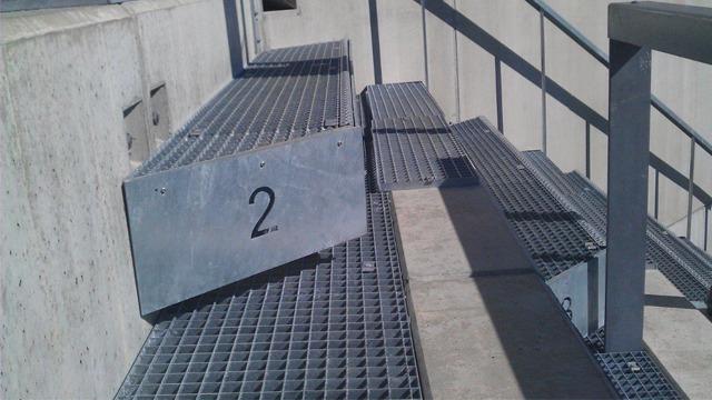 Trappen med nummer 2, laget av metallgitter, på en moderne bygning.
