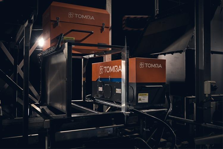 TOMRA-maskiner i en industriell setting, med fokus på resirkulering og avfallshåndtering.