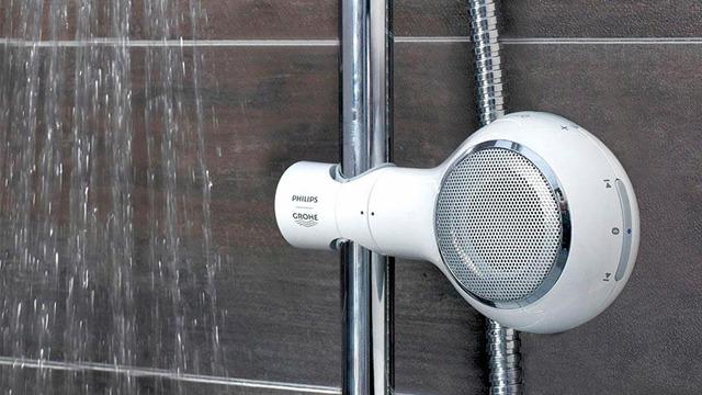 Dusjhøyttaler fra Philips montert på dusjveggen, med vann som renner ned fra dusjhode.
