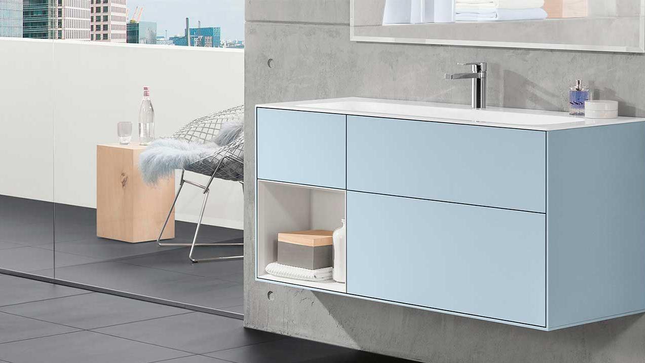 Moderne baderom med en lys blå vaskeskap, speil og minimalistisk interiørdesign.