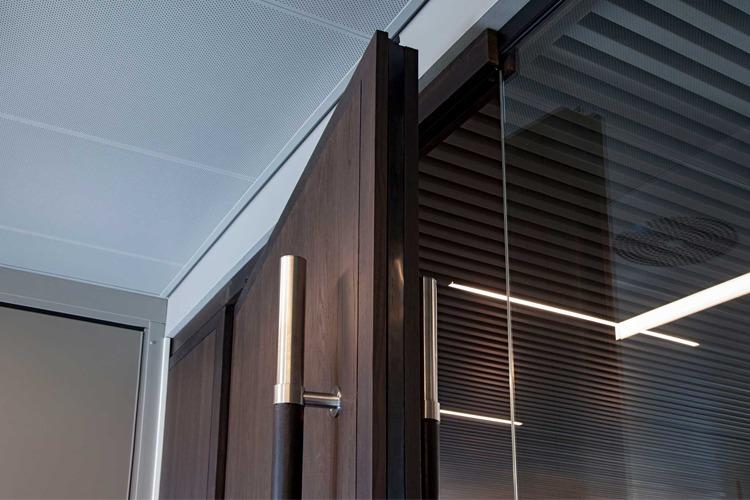 Moderne glassdør med treverk og metallhåndtak i et stilrent interiør.