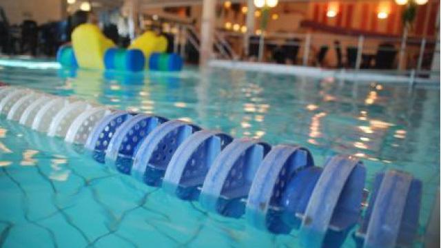 Simsport med blå og hvite baneskiller i et innendørs svømmebasseng.