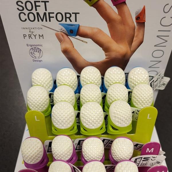 Hånd med ergonomiske syfingerbeskyttere i forskjellige farger på en utstillingsstativ.