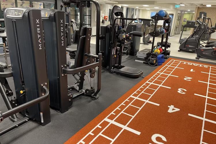 Treningsstudio med Matrix treningsutstyr og en løpebane i fokus, perfekt for styrke- og kondisjonstrening.
