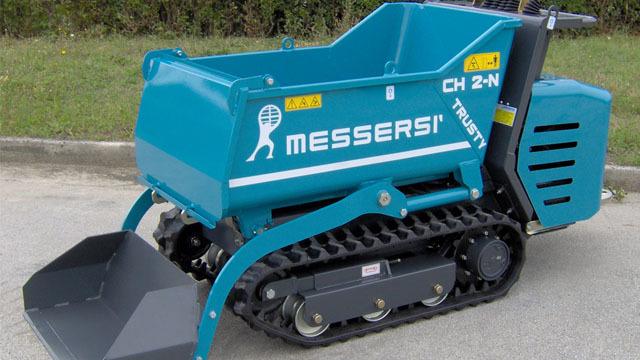 En blå minigraver med belter og skuff, merket Messersi CH 2-N, står på en grusvei.