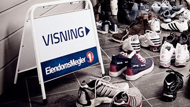 Skilt for visning med eiendomsmegler, omgitt av ulike sko på gulvet.