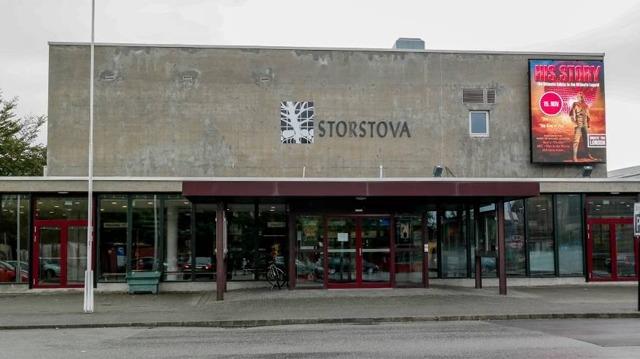 Inngangen til Storstova med stor plakat og moderne fasade i grått.