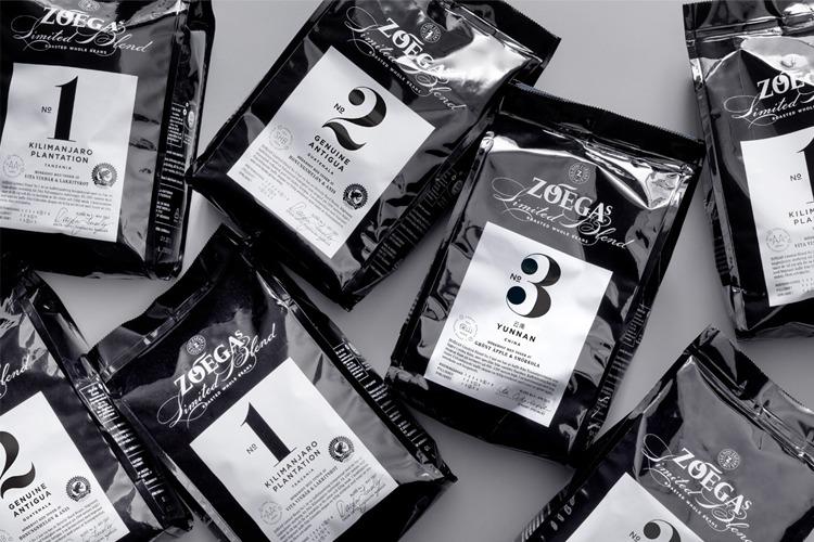 Pakker med Zoegas kaffe i svart og hvitt design, nummerert fra 1 til 3, ligger på en grå overflate.
