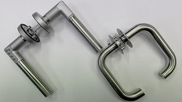 To dørhåndtak i rustfritt stål med moderne design, plassert på en lys bakgrunn.