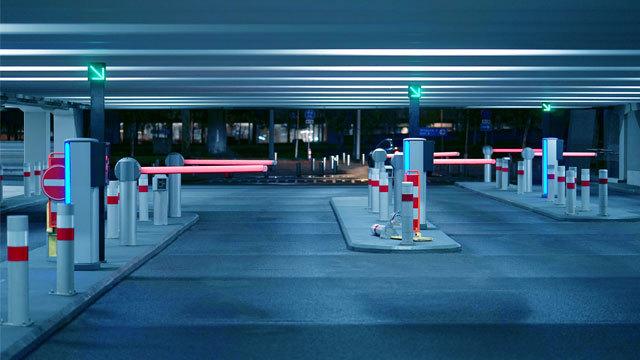 En moderne parkeringskjeller med automatiserte bommer og lys, som viser ledige parkeringsplasser.