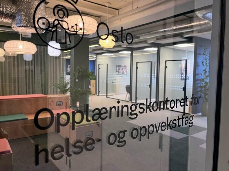 Oslokontor med skilt for opplæringskontoret for helse og oppvekstfag, moderne interiør og glassdører.