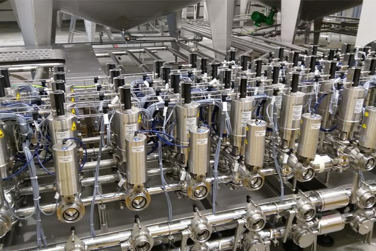 En rekke industrielle ventiler og rørledninger i et moderne produksjonsanlegg.