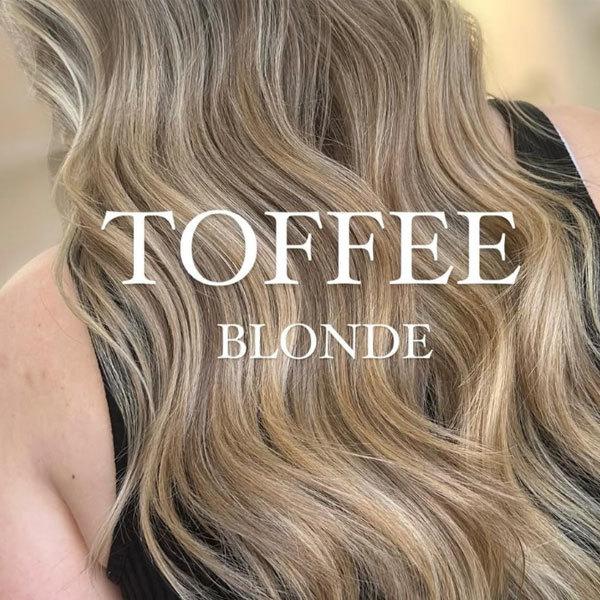 Langt, bølgete hår i toffee blond nyanse med naturlig glans.