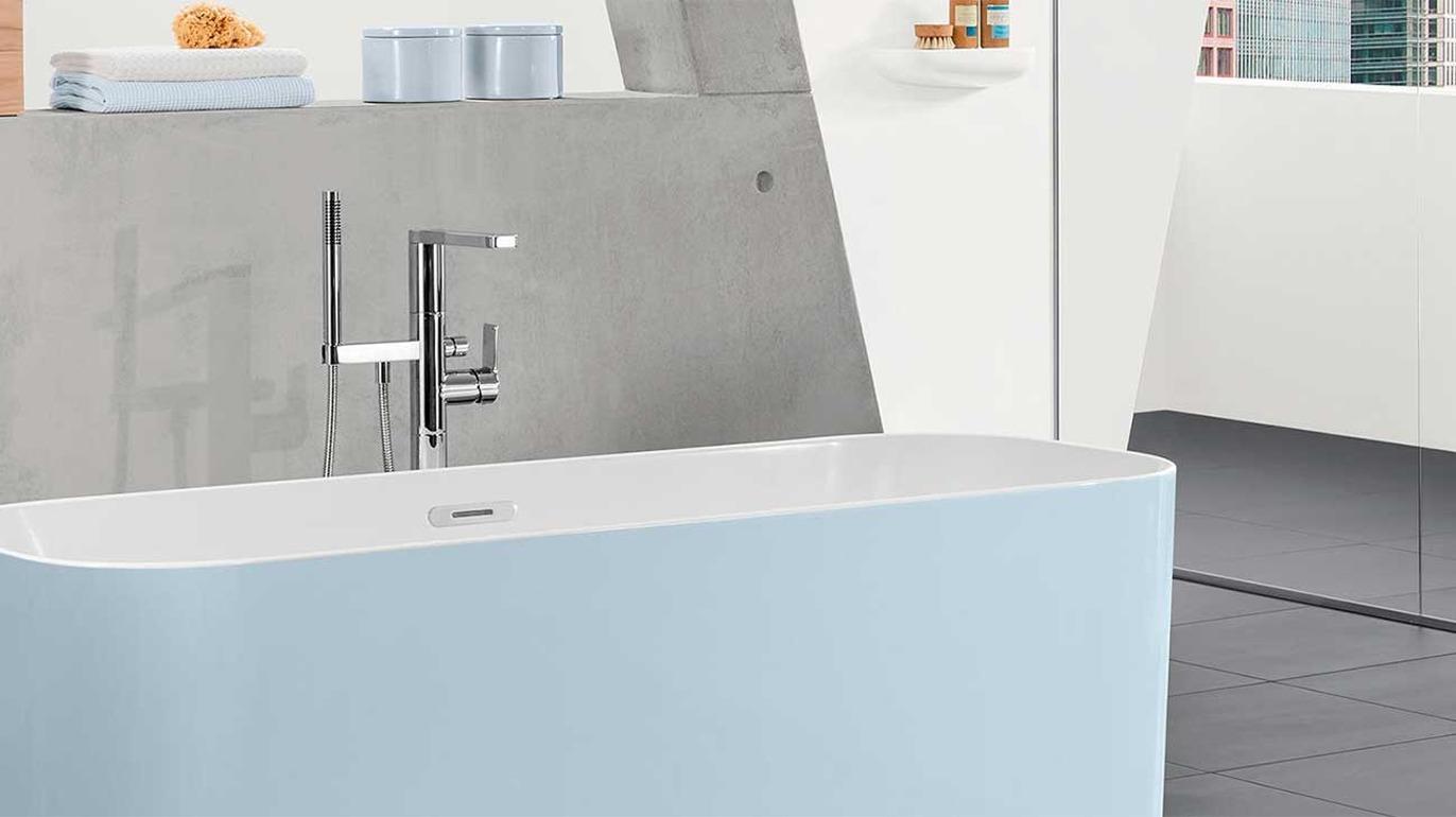 Moderne bad med en lys blå badekar, stilren kran og minimalistisk interiørdesign.