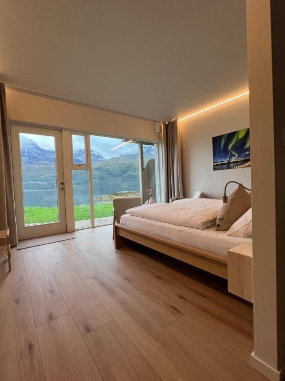 Moderne soverom med dobbeltseng, store vinduer og utsikt over fjellene og landskapet utenfor.
