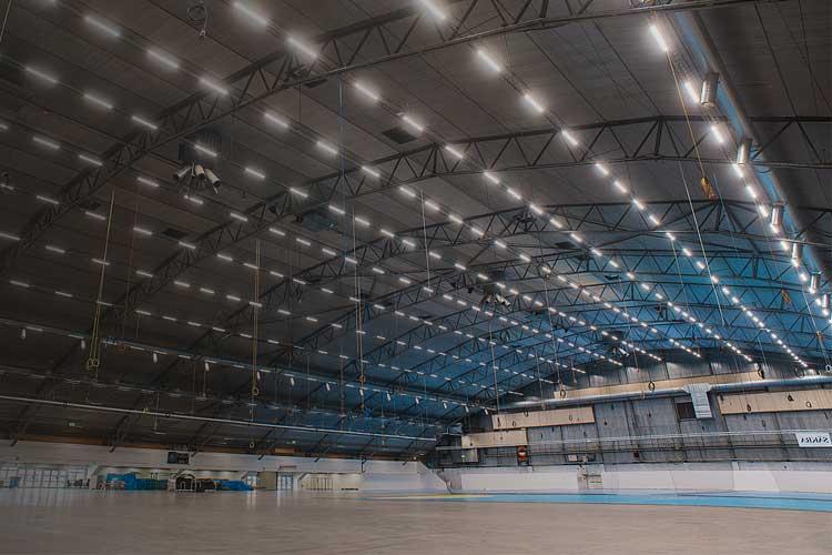 Innendørs idrettshall med høyt tak og moderne belysning, klar for trening og konkurranser.