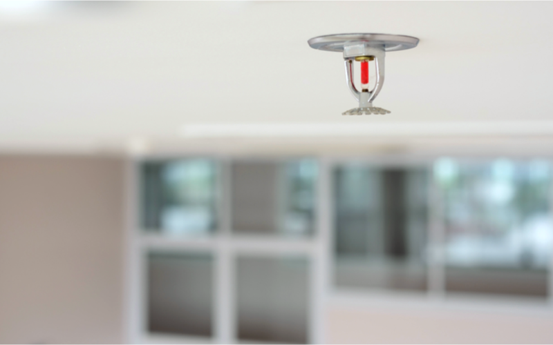 Sprinkleranlegg i taket i et moderne rom med uskarpe bakgrunner.