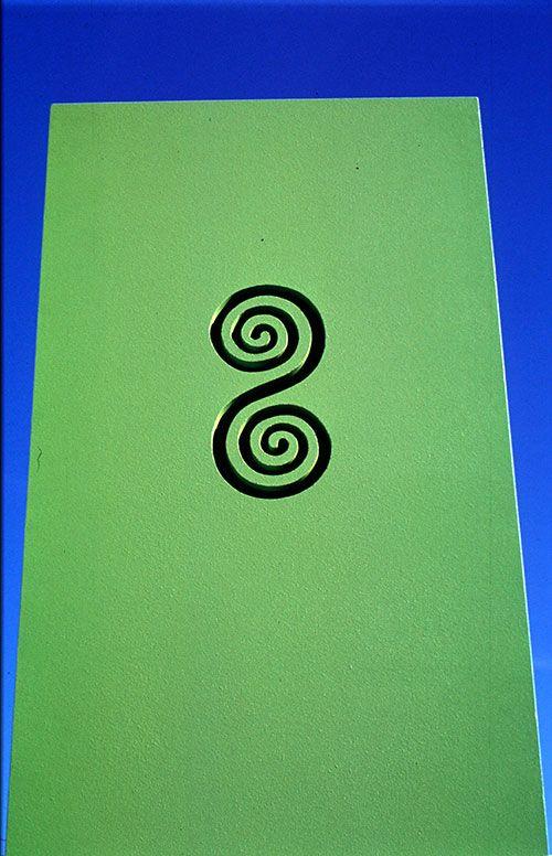 Grønn bakgrunn med to svarte spiraler i midten, som danner et unikt og kunstnerisk design.