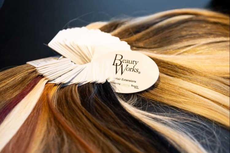 Fargeprøver av hårforlengelser fra Beauty Works, med ulike nyanser av hår i en fanned ut form.