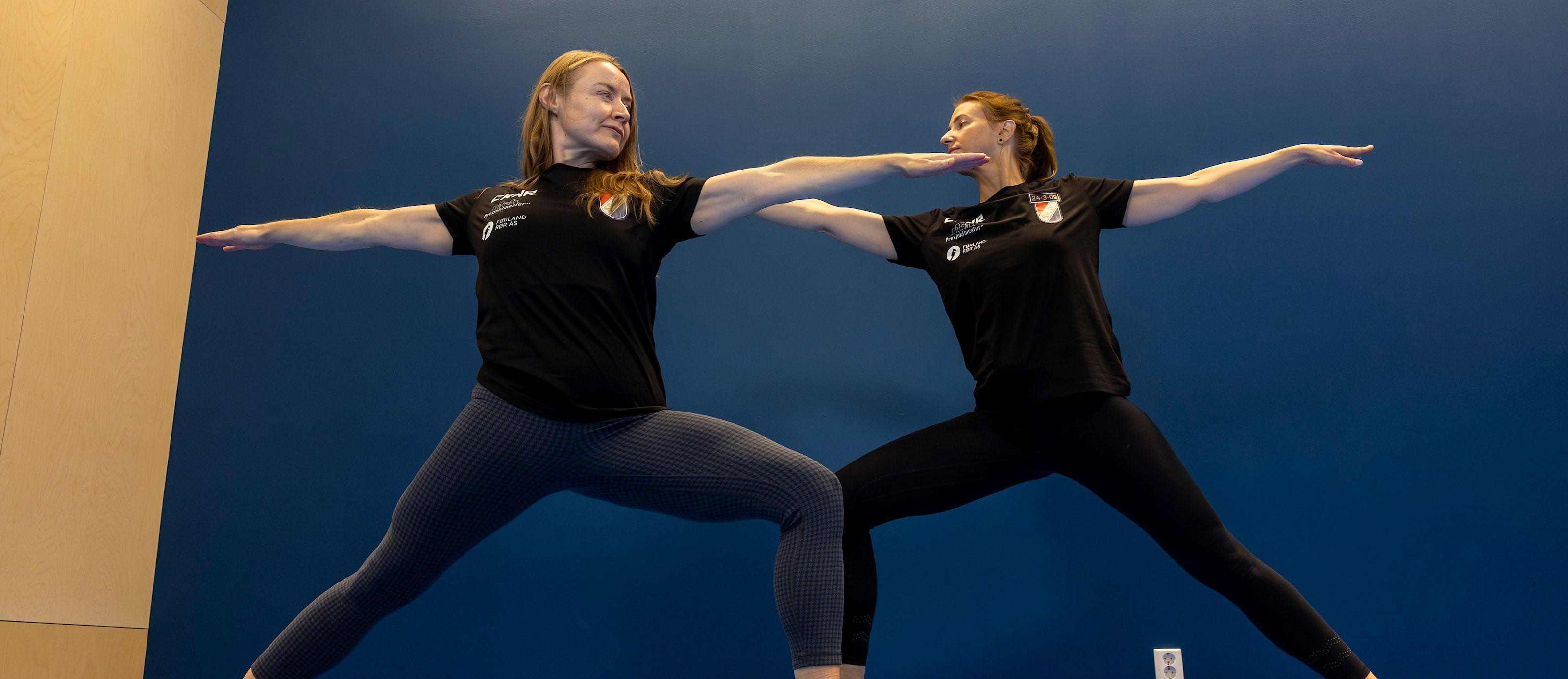 To kvinner i yogaposisjoner med utstrakte armer på en blå bakgrunn.