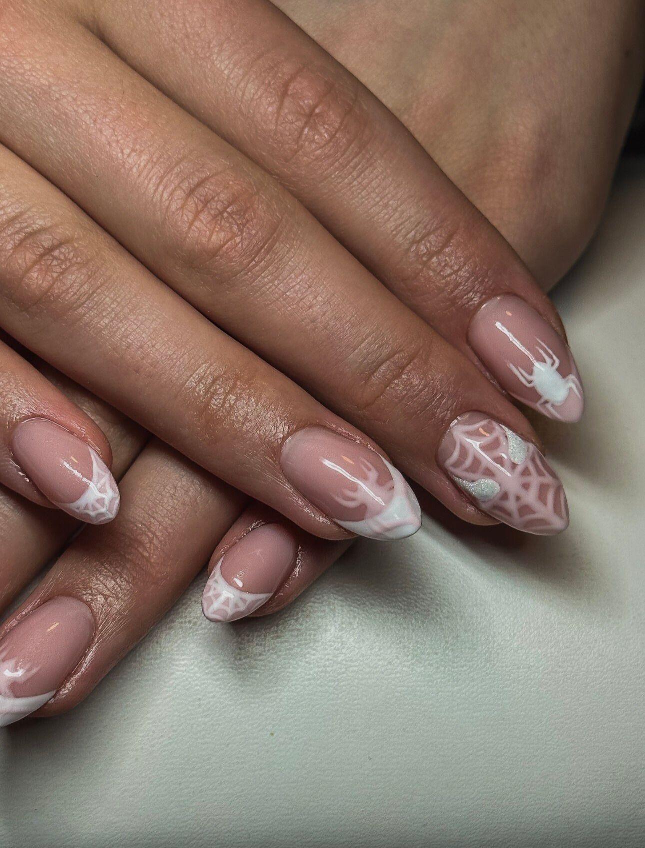 Naildesign med rosa og hvite farger, inkludert edderkopp og spindelvev på neglene.