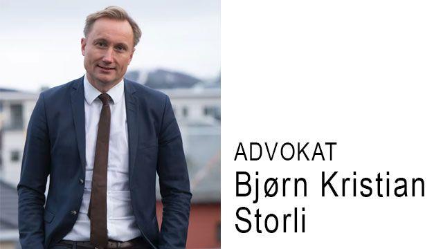 Advokat Bjørn Kristian Storli står iført dress med en bybakgrunn.