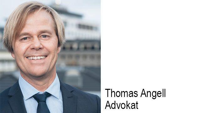Thomas Angell, en smilende advokat med blondt hår, står foran en moderne bygning.