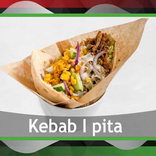 Kebab i pita med grønnsaker og saus, servert i en papirbeholder.