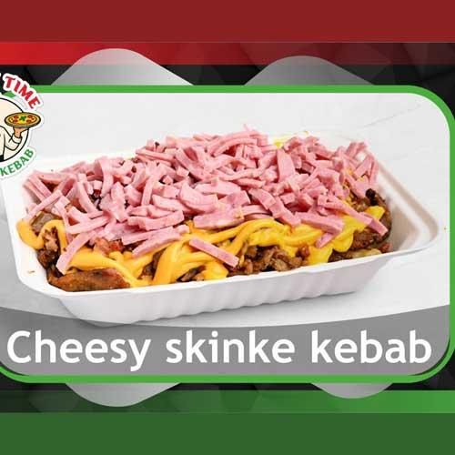 En tallerken med cheesy skinkekebab, dekket med smeltet ost og strimlet skinke.