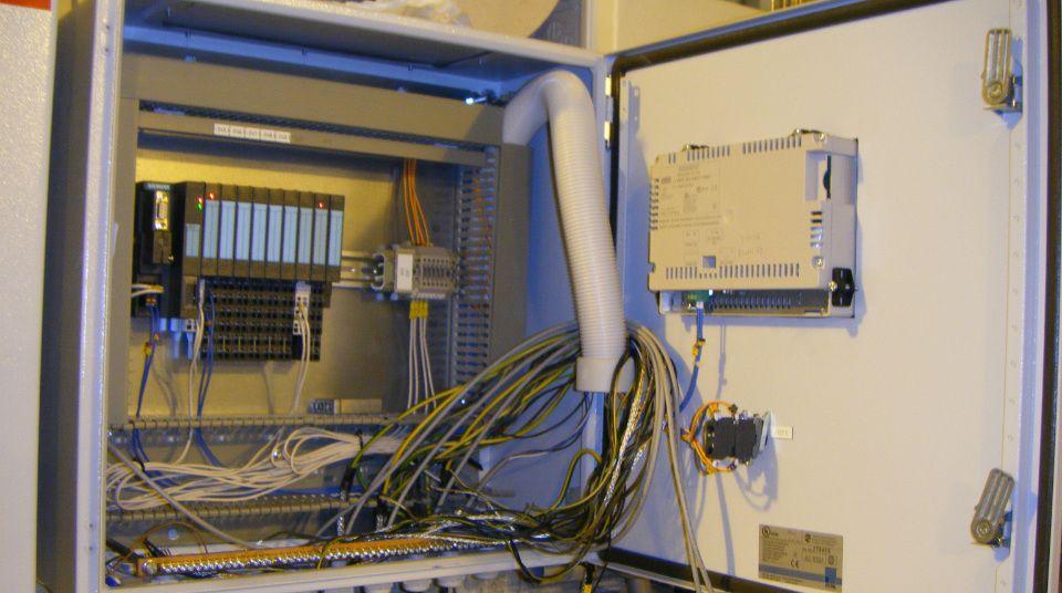 Innvendig bilde av et elektrisk skap med kabler og komponenter for industriell automatisering.