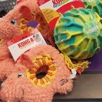 Fargerike KONG leker for hunder, inkludert en rosa gris og en fargerik ball, ligger på en butikkdisk.