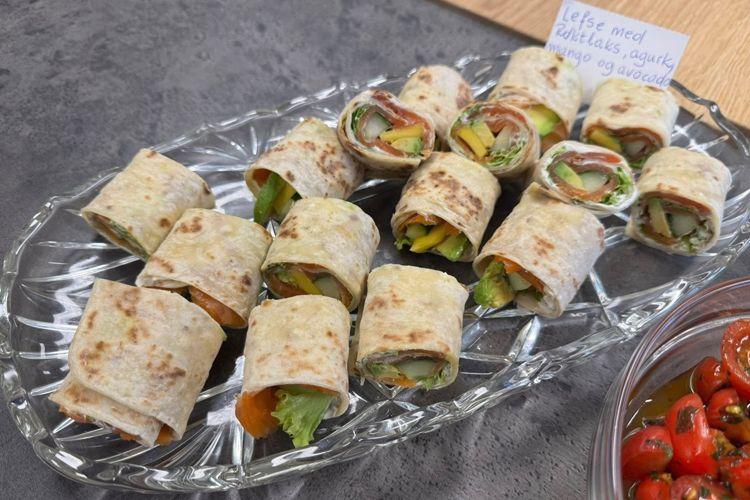 En tallerken med rullekebab laget av tortilla, fylt med grønnsaker og skinke, ser fristende ut.