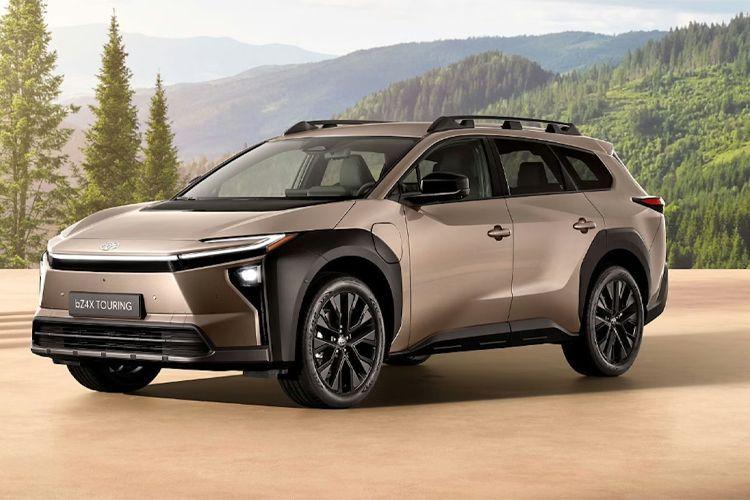 En moderne SUV parkert i naturen med fjell og trær i bakgrunnen, med en elegant brun farge og stilige detaljer.