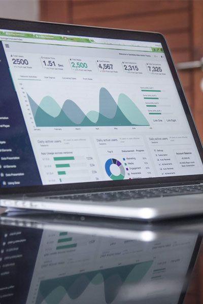 En bærbar datamaskin viser detaljerte analyser og grafer på skjermen, med fokus på data og statistikk.