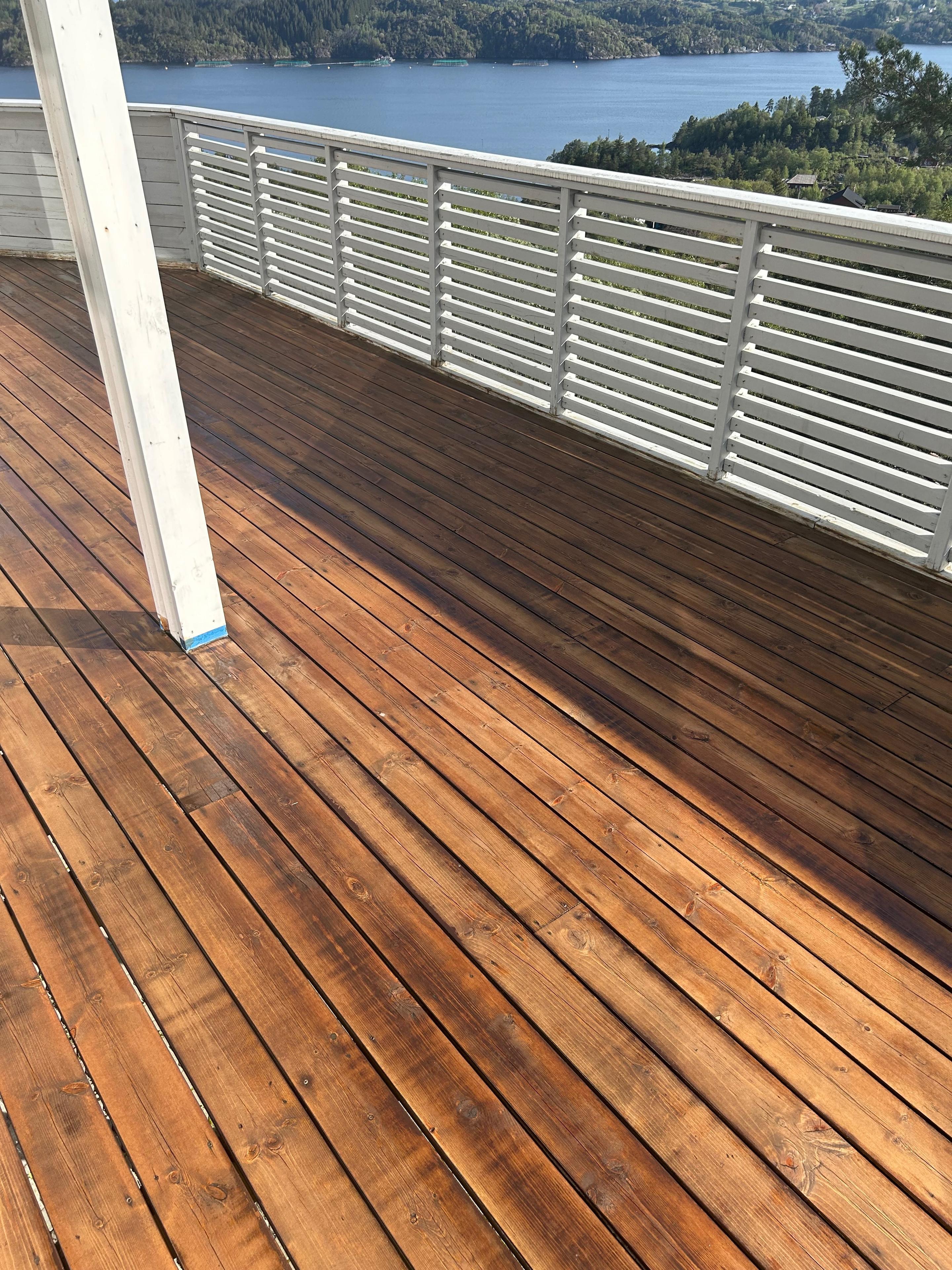 Trevlig terrasse med nybehandlet treverk og utsikt over vannet og landskapet.
