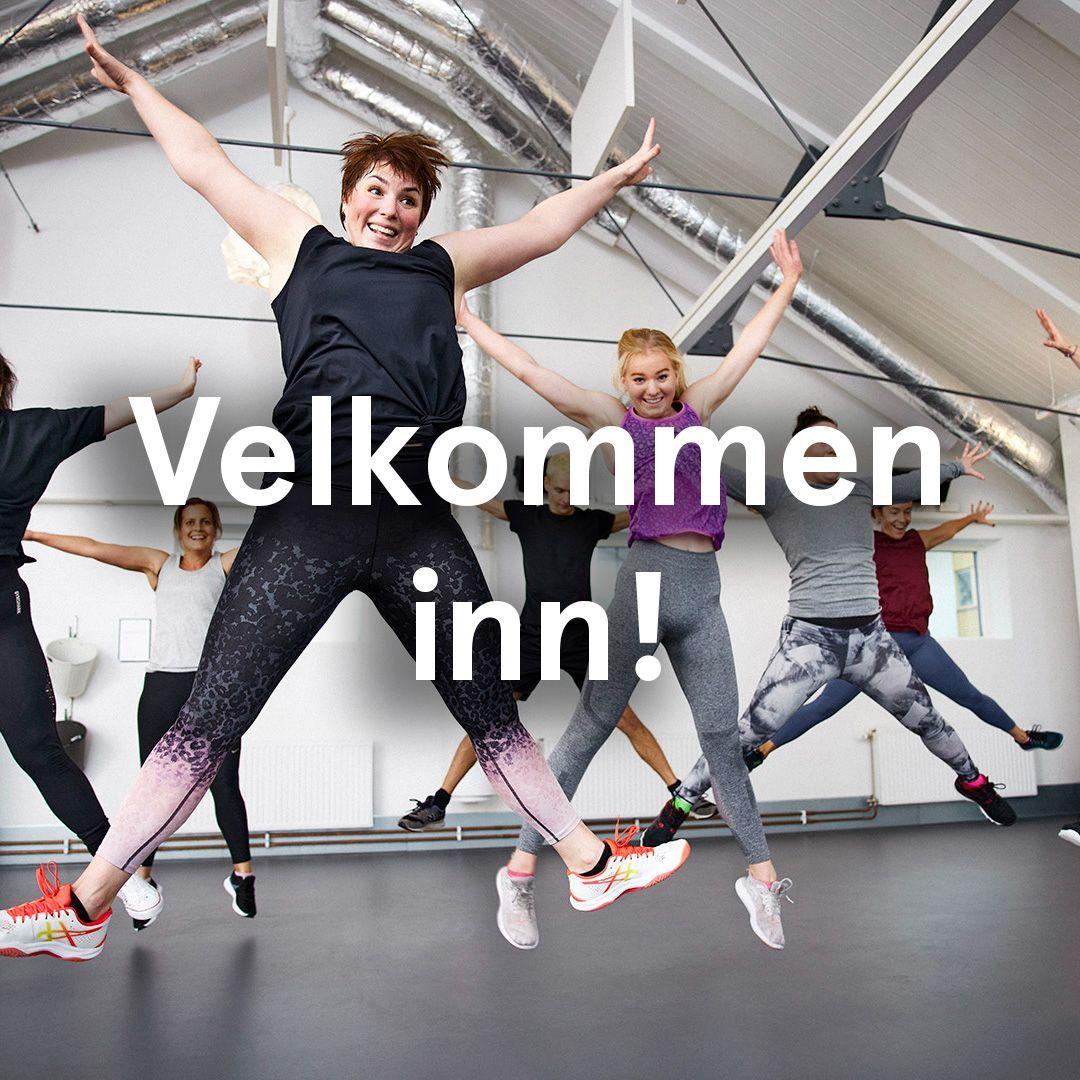 En gruppe glade mennesker som hopper under en treningsøkt i et lyst rom. Teksten "Velkommen inn!" er synlig.