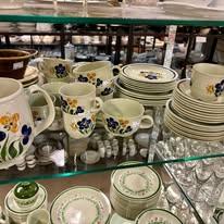 Kopper, tallerkener og glass med blomsterdesign i en utstilling av porselen i en butikk.