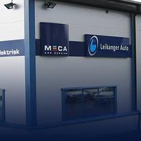 Bygning med skilt for Leikanger Auto og MECA, med blå detaljer og vinduer i front.
