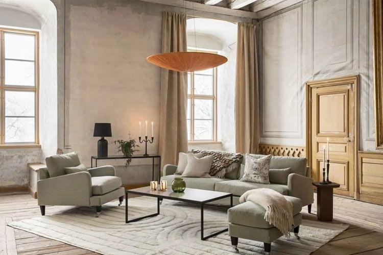 Moderne stue med lys grønn sofa, bord, lamper og store vinduer som slipper inn naturlig lys.
