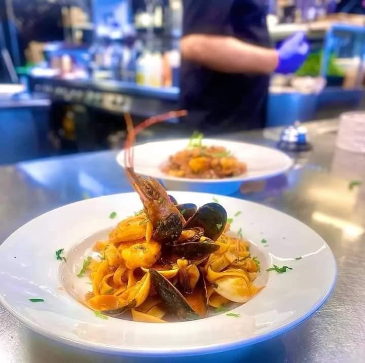 En tallerken med pasta og skalldyr, inkludert reker og blåskjell, ser appetittvekkende ut i en restaurant.