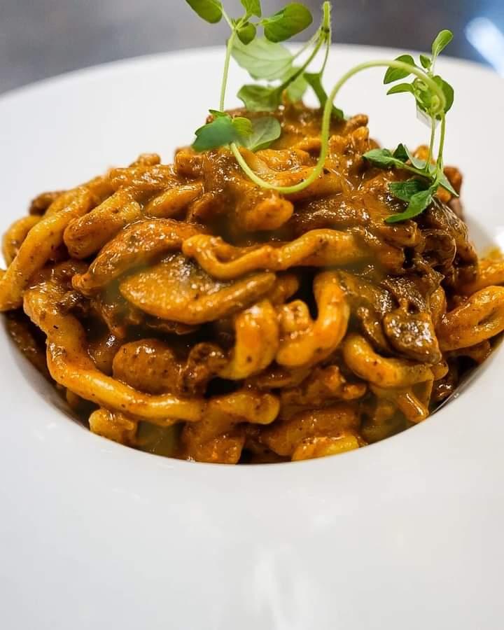 En tallerken med pasta i en kremet saus, pyntet med friske urter.