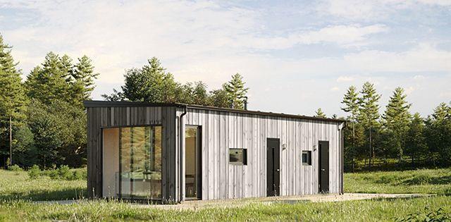 Moderne enebolig med trepanel og store vinduer, omringet av grønt gress og trær.