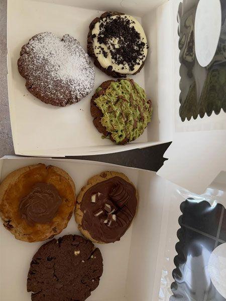 Boks med seks forskjellige småkaker, inkludert sjokolade, kokos og nøttefyll.