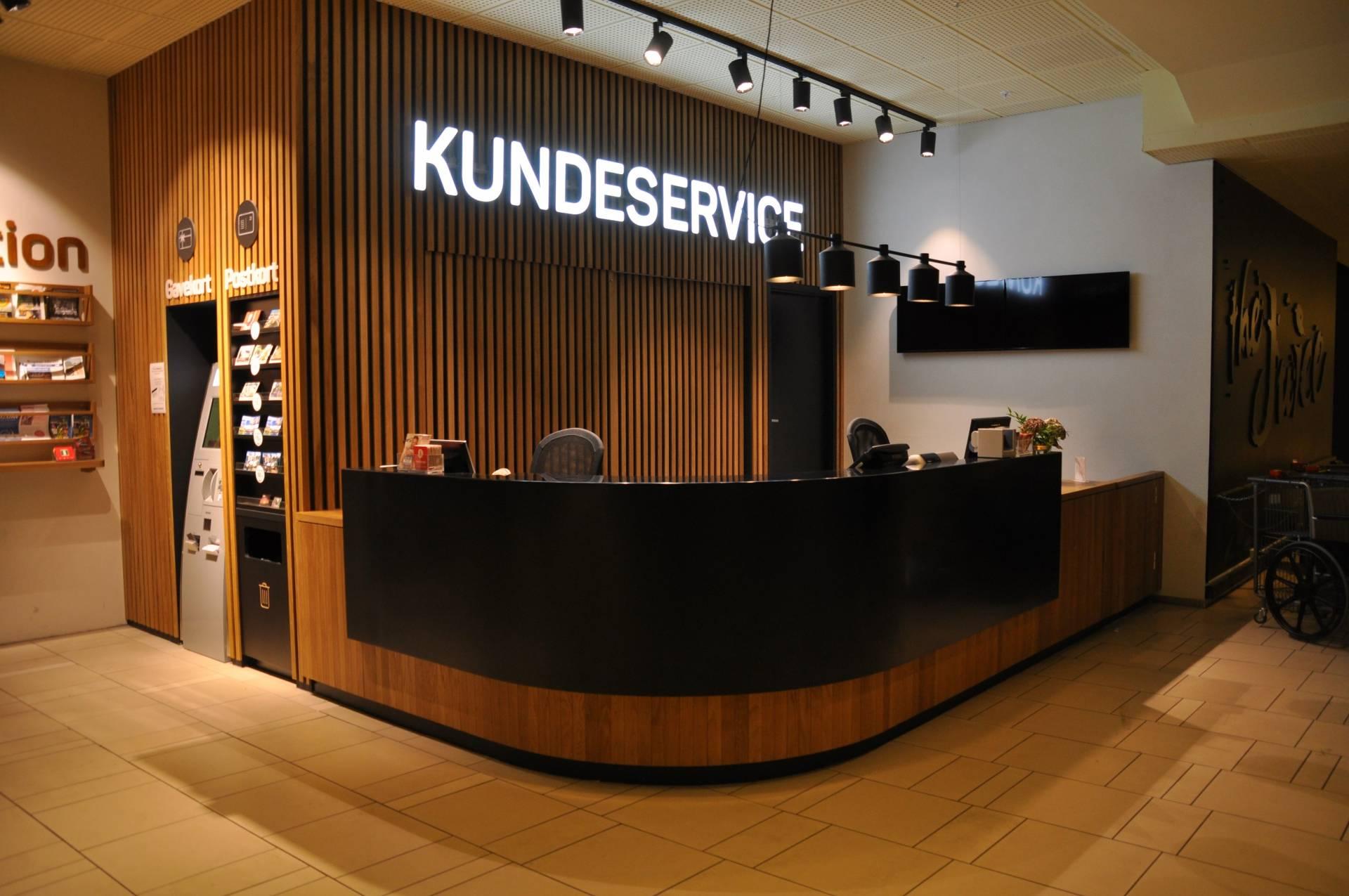 Kundeservice-resepsjon med tre lamper og tre hyller i en moderne innredning.