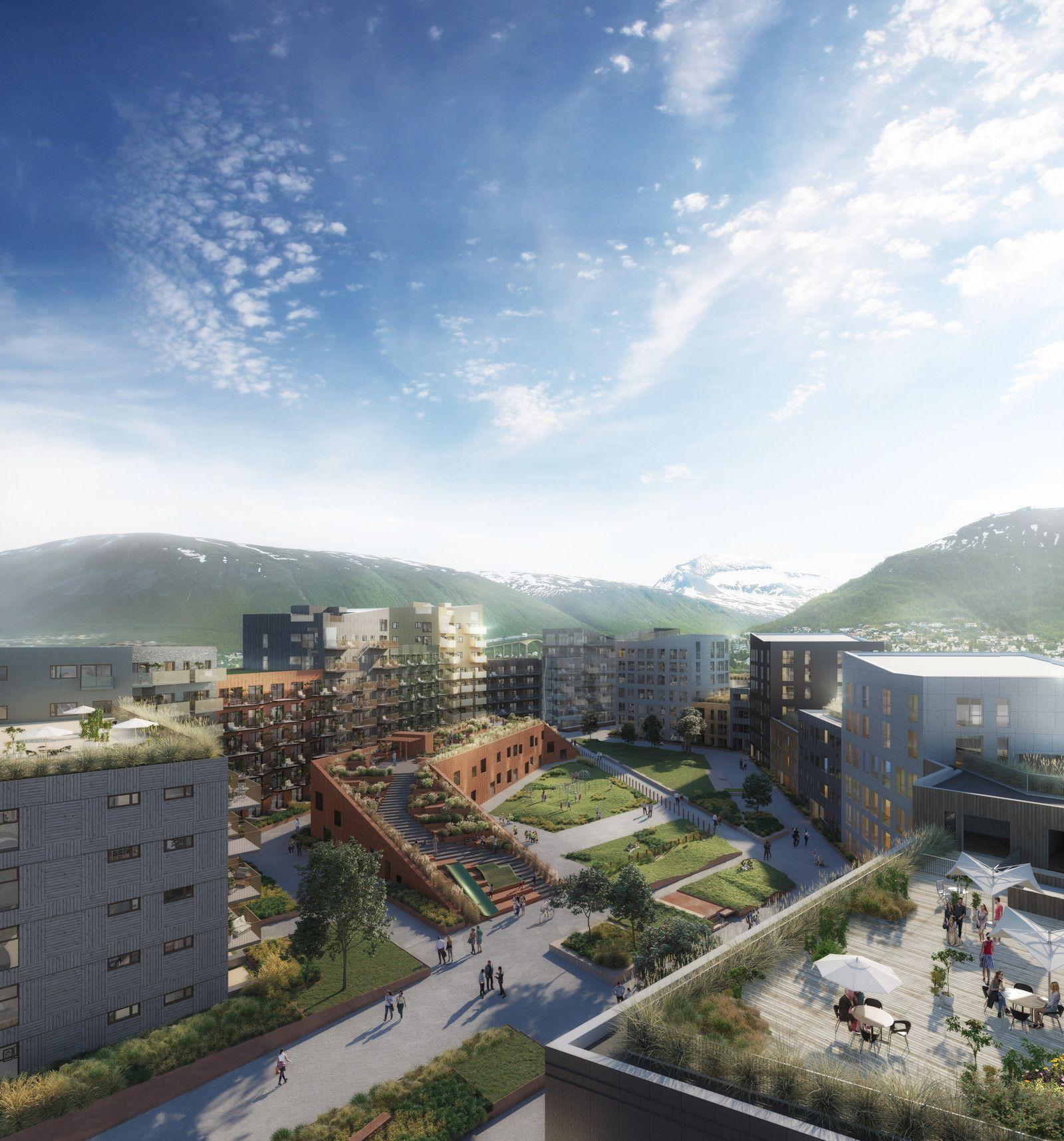 Moderne boligområde med grønne områder, bygninger og fjell i bakgrunnen under en klar himmel.
