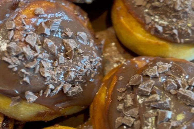 Fristende kanelboller med sjokoladeglasur og hakket sjokolade på toppen.