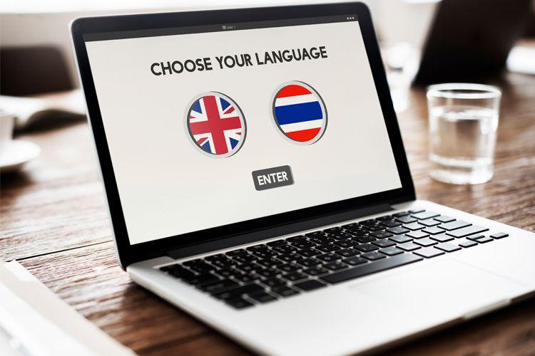 En bærbar datamaskin med skjerm som viser språkvalg mellom engelsk og norsk.