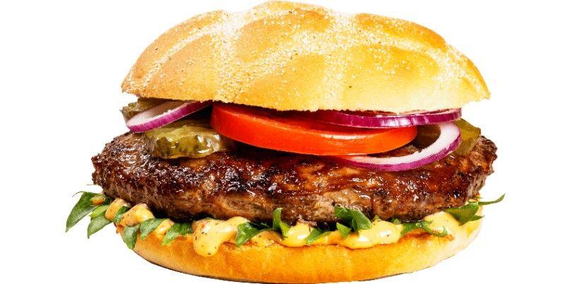 Saftig hamburger med salat, tomat, løk, pickles og dressing i en myk hamburgerbolle.